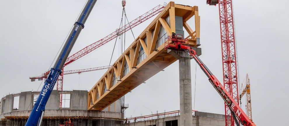 Der 500 Tonnen schwere Kran setzt den 50 Meter langen Holzbinder punktgenau auf die Betonstütze © Europa-Park Resort