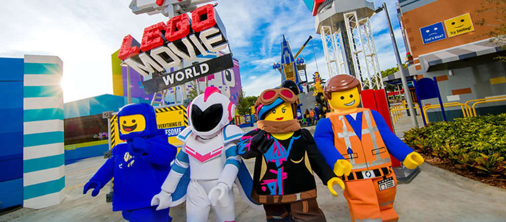 Die Helden aus dem Lego Film schreiten durch das Eingangstor der Lego Movie World